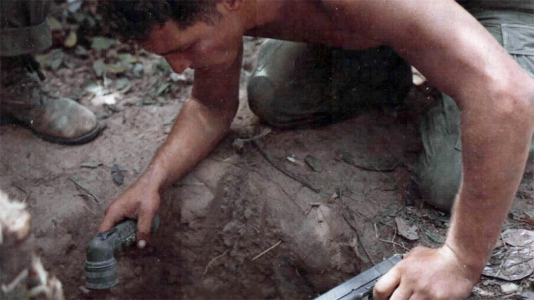 A tunnel rat stares into the dark abyss of the Vietnam underground.