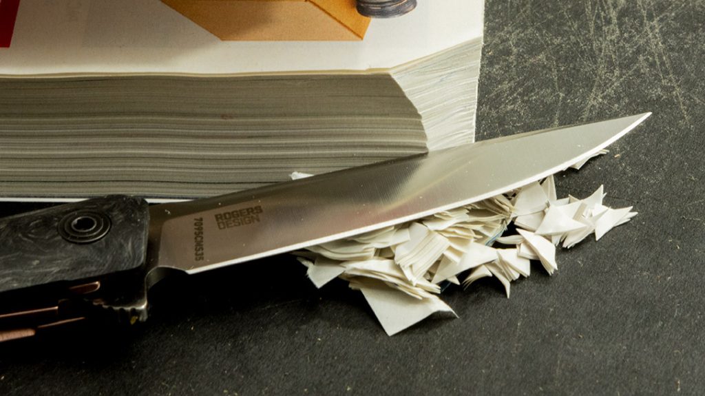 Although I had to slice through, the CRKT CEO Compact Carbon Fiber got all the way through the phone book.
