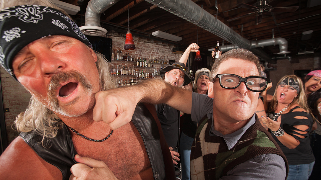 Confident geek punches mature biker gang man on chin