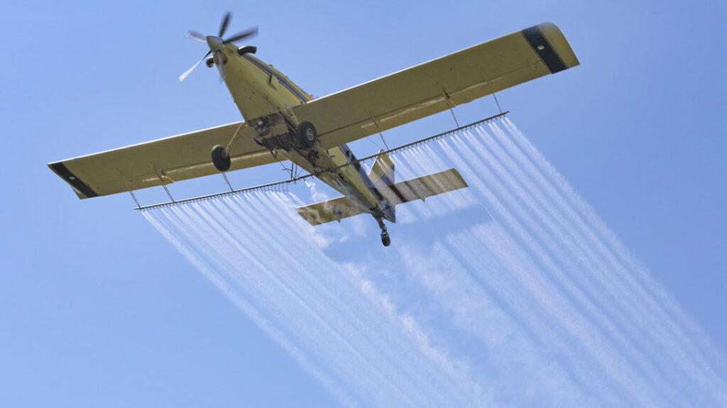 plane flying over crops