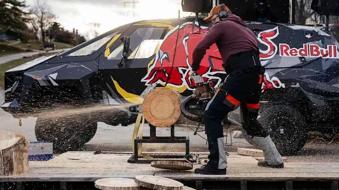 Sawdust flies as Matt Cogar slices a chainsaw through a massive log.
