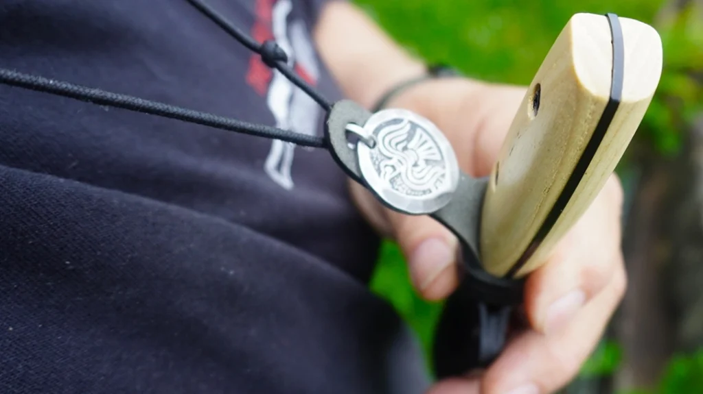 During the discussion with the Morakniv sales rep regarding the Ash Wood Outdoor Collection, I was told the Finn sheath is designed to be snapped onto a large button.