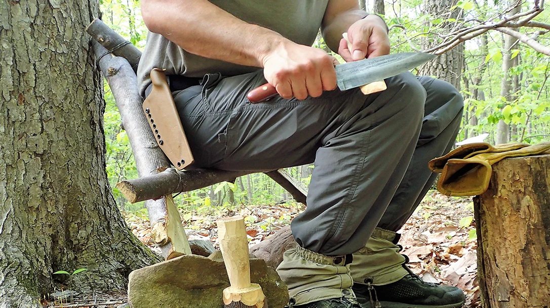 The author used the completed Roycroft-style chair/stool against a tree. Its sturdy wood and super-strong  Canadian Jam and Constrictor knots make it a solid pack frame and seat choice.