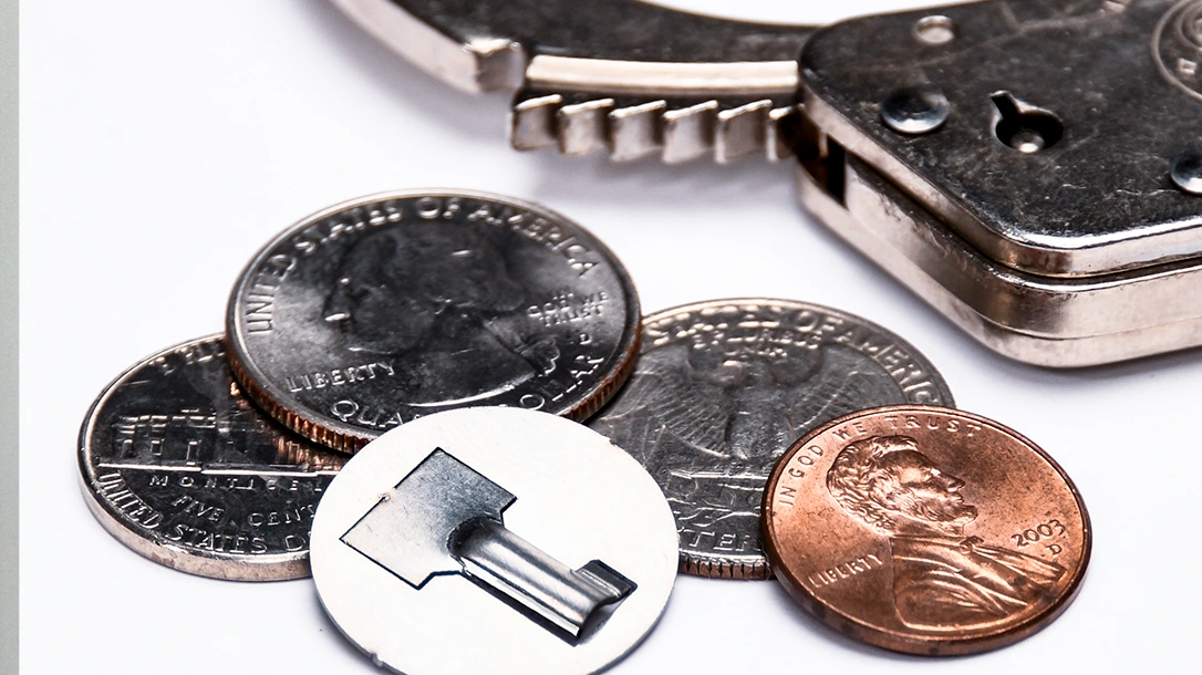 A universal handcuff key is small and compact. Here, it is hidden within a fake coin.