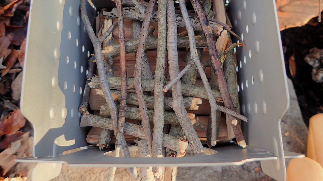 The author split hardwood, placed it at the bottom, and added fuel perpendicularly until it culminated in thin kindling and tinder on top.