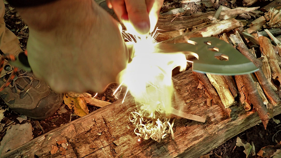 The author made thin, curly feather-sticks by planting the heel of the Stoke hatchet firmly in wood and drawing sticks back against the sharp blade.