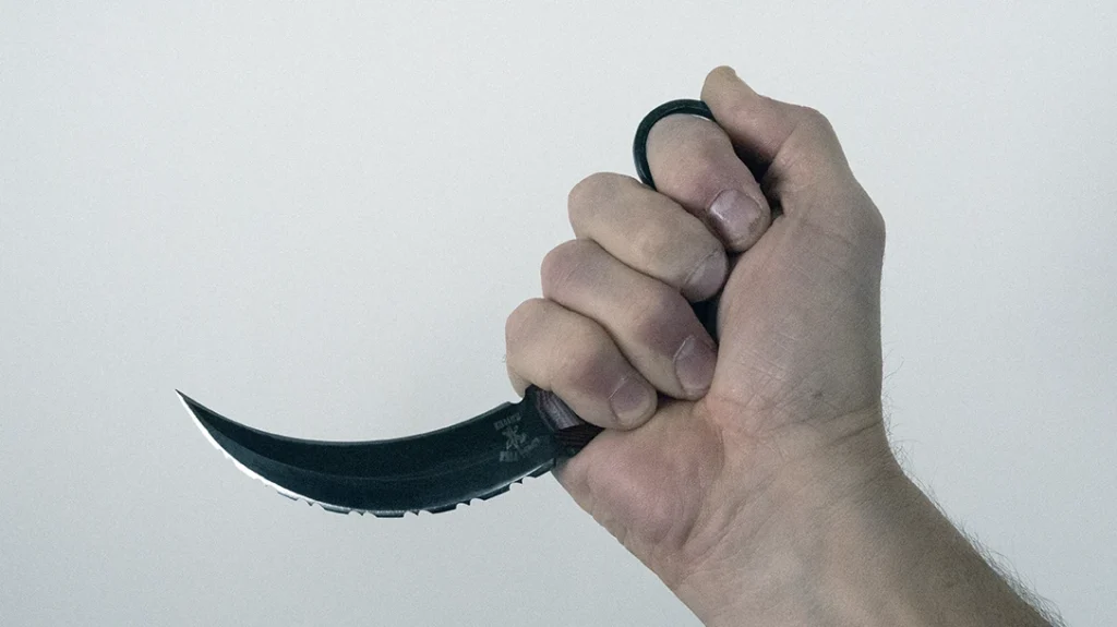 The retracted grip with the karambit stabilizes the blade firmly for powerful cutting with both edges.