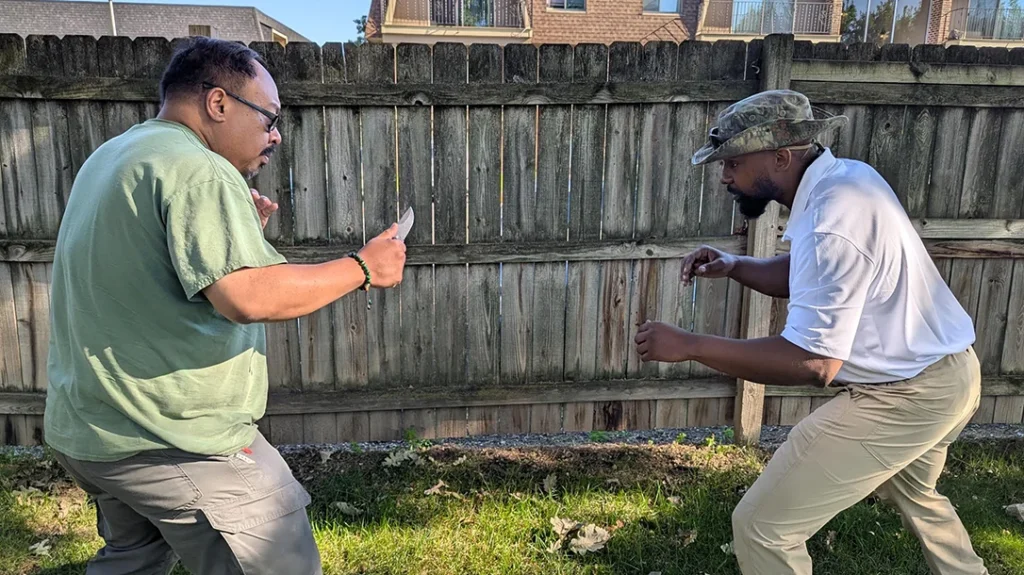 Frank holds his Boker Plus Kagat ready to defend himself against Cass.
