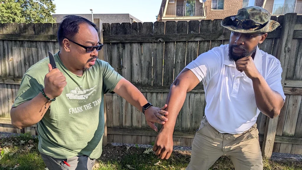 Frank clears Cass’s cut arm and chambers his knife for the next attack.