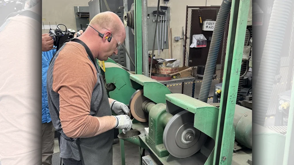 Buck Knives employee hand-sharpening a Model 119 knife.