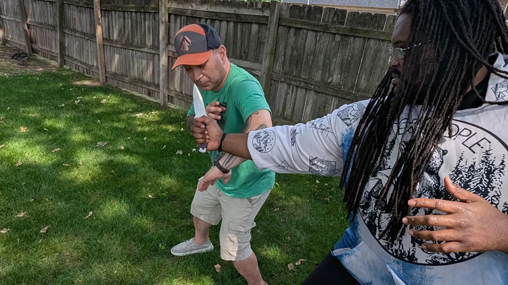 Knife Fighting Myths: Author “blades” steps off angle and deflects the attack with his forearm.