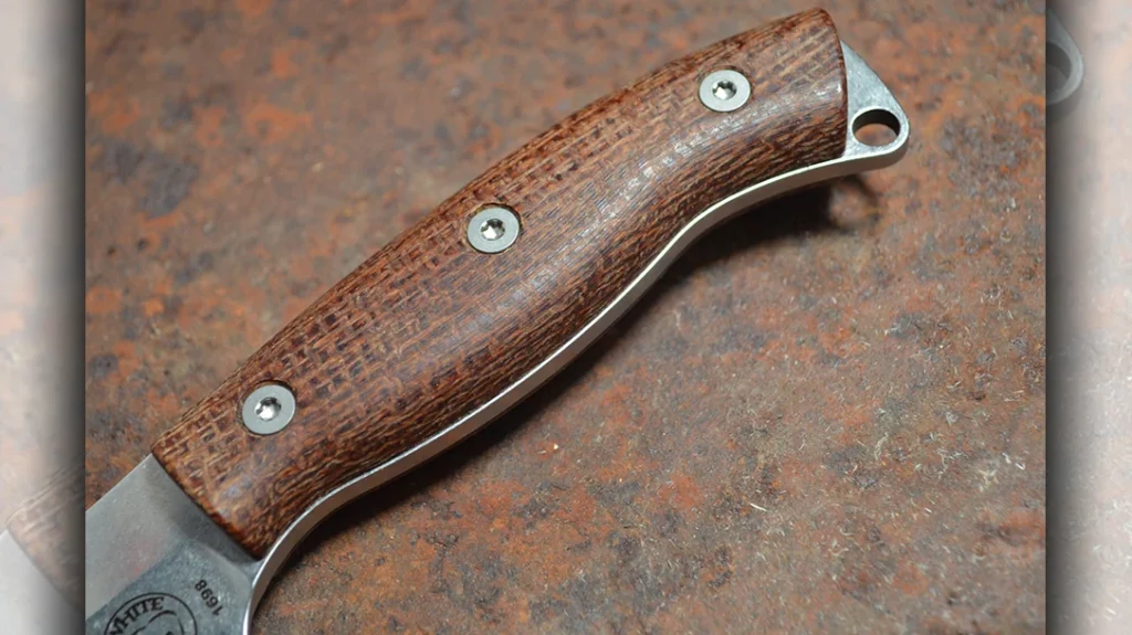 The tang juts out just slightly from the handle scales. This is part of the design and is surprisingly comfortable.