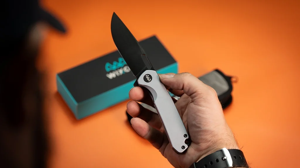 The WIXCO Knives Pexston is the sleeper. It is a liner-lock flipper with bead-blasted aluminum scales and a black-coated blade and hardware, including the stud.