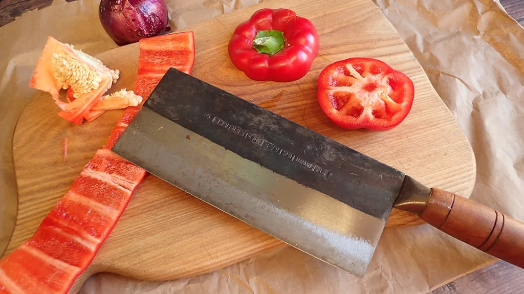 The Chinese Veggie cleaver completing a roll cut on a red pepper.