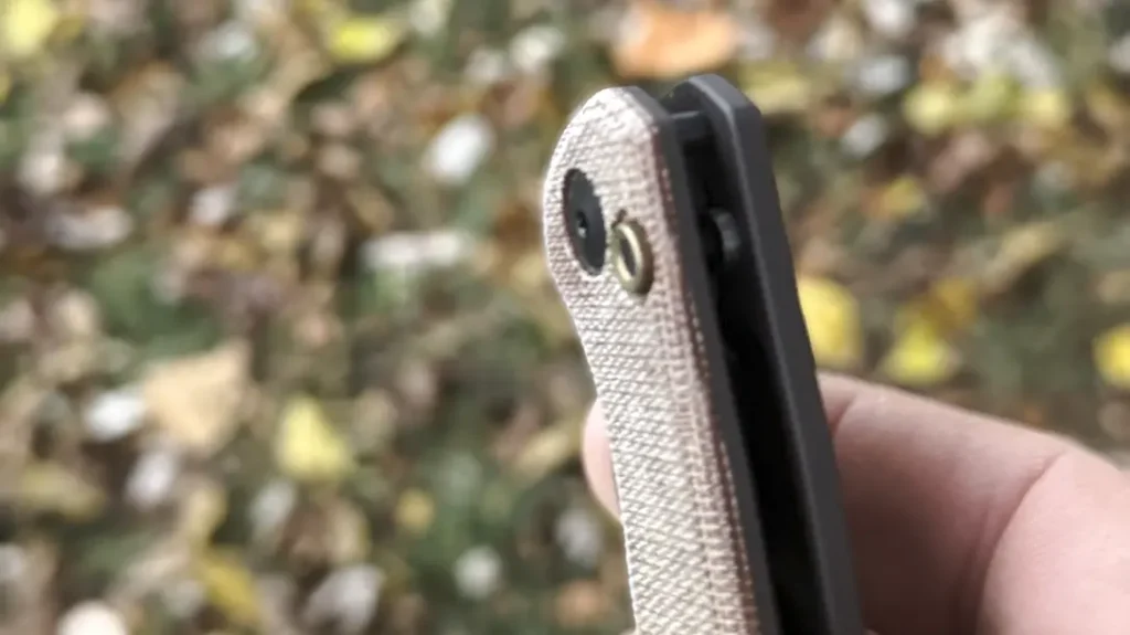 The bronze anodized lock button sits proud of the micarta show side handle scale. It is prominent enough to be easy to use but not so much as to cause an accidental opening.