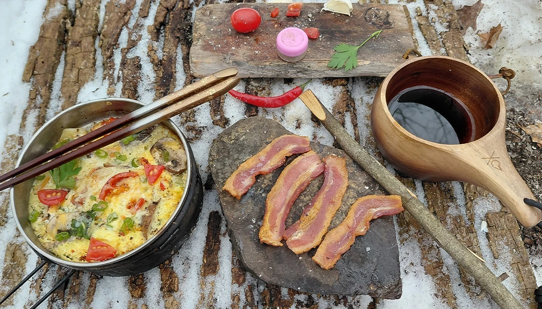 Bacon sizzling on a heated rock over a glowing campfire—nature’s skillet at work.