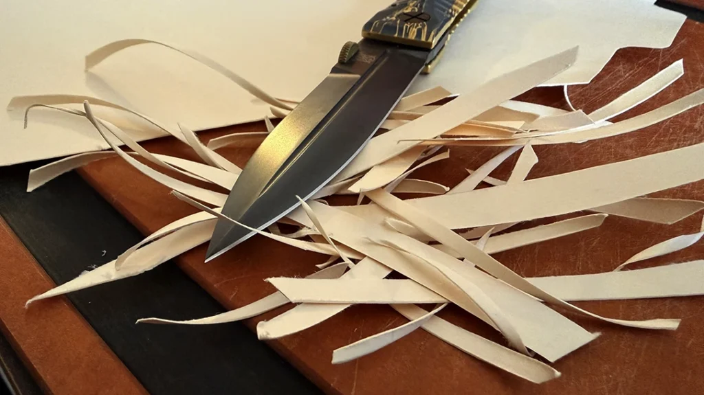 The Elishewitz Les George Ek Integral Folding Knife easily sliced through a manila folder, even producing some fine curls.