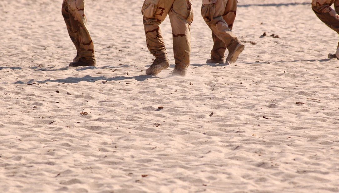 US soldiers advancing during the Iraq ground offensive in desert terrain.