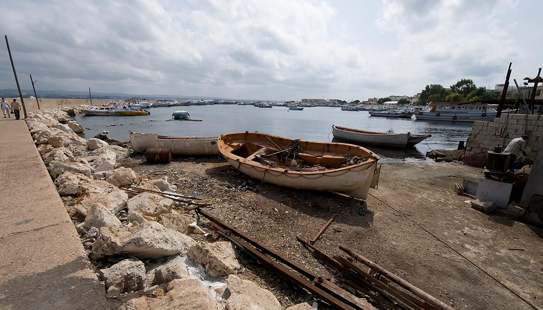 Arward harbor boats lie on the shore.