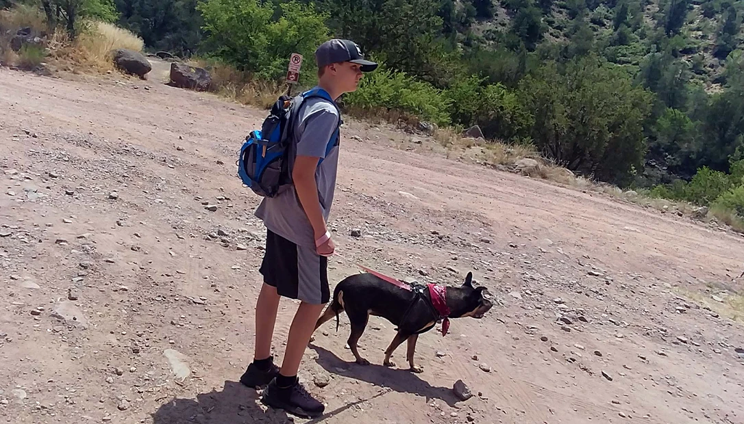 Dog and owner hiking a remote desert trail.
