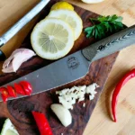 Beginner practicing basic kitchen knife skills on a cutting board with vegetables.