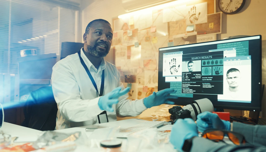 Forensic ballistics expert examining shell casings through a microscope for IBIS analysis.