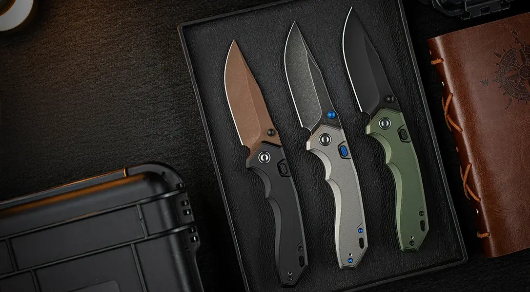 Three CIVIVI Elite Brova knives in three colors sitting on a desk.
